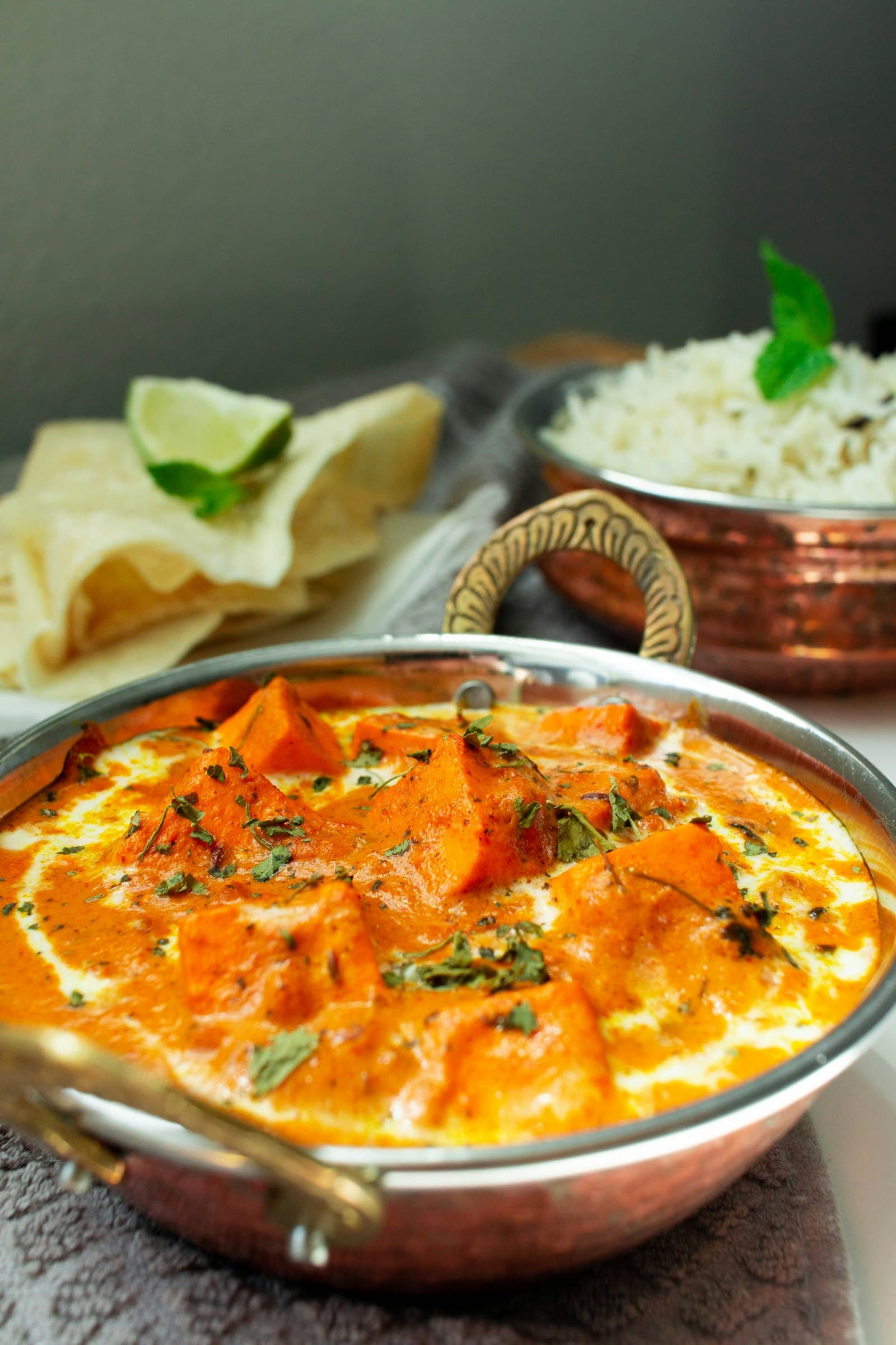 A bowl of creamy paneer curry with rice and papad